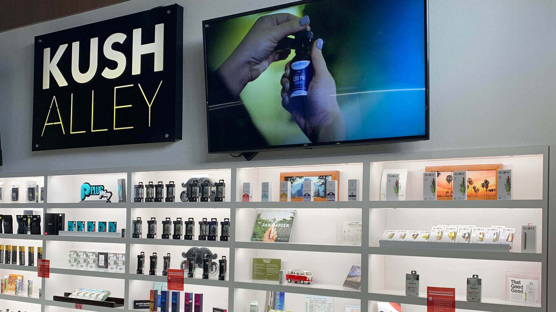 Dispensary point-of-purchase DOOH screen above store shelves